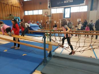 Kinder in der Turnhalle an verschiedenen Stationen